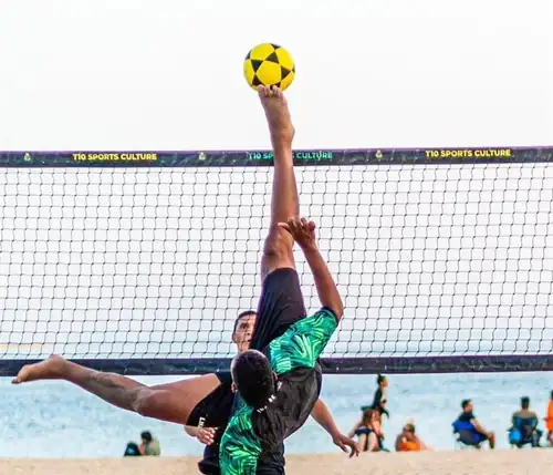 Atletas a jogar futevólei na areia